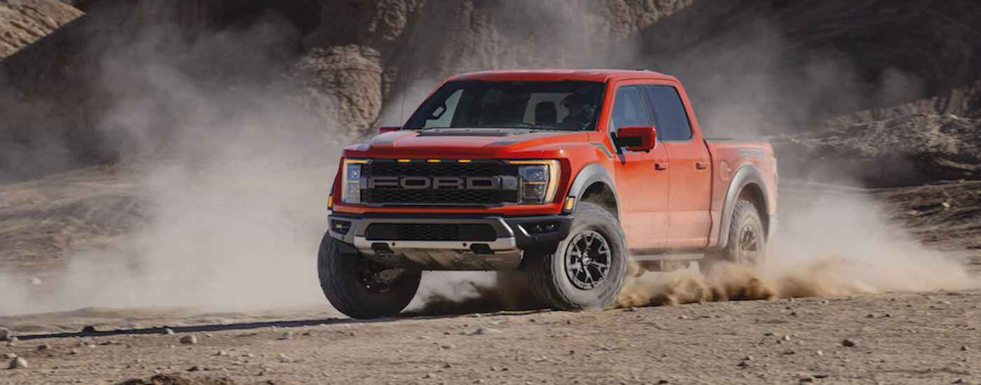Red 2021 Ford F-150 Raptor drifting off-road
